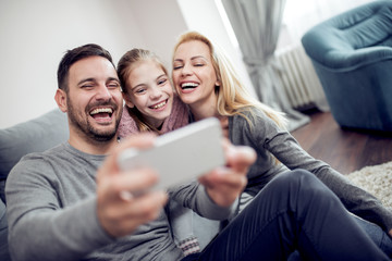 Happy family taking selfie in their house