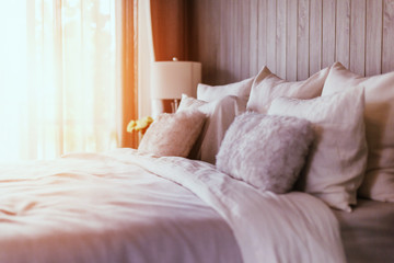 light soft pillow on beautiful bed cozy bedroom with sun light from window interior concept