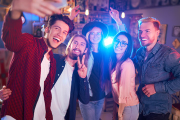 Selfie Time. Young Group of Friends Partying In A Nightclub And Toasting Drinks. Happy Young People With Cocktails At Pub. The People Have A Great Mood And They Smile A Lot.