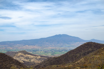 Fototapeta premium View to the green valley, dry forest hills and mountains at the background