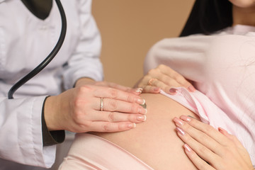Obraz na płótnie Canvas Pregnant belly check with stethoscope