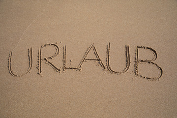 Fototapeta na wymiar Das Wort URLAUB in den Sand geschrieben