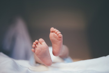 tiny feet of a newborn baby in focus during the diaper changes