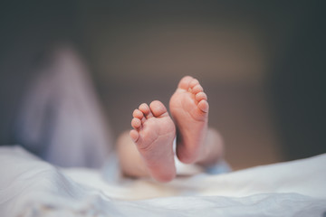 tiny feet of a newborn baby in focus during the diaper changes