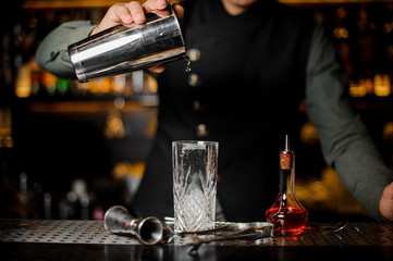 Fototapeta na wymiar Bartender is making cocktail at a bar counter