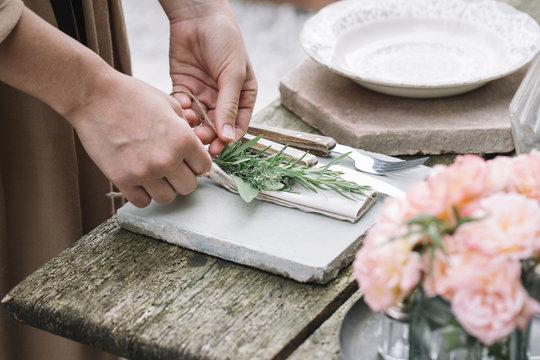 Woman decorating napkin with fresh green