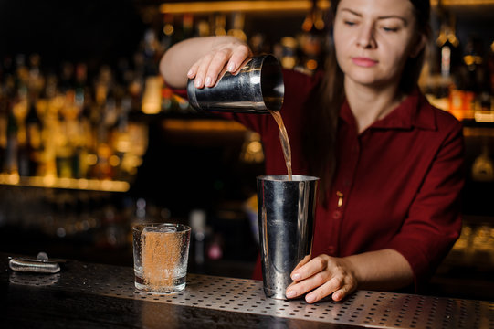 Bartender girl making cocktail at the bar counter