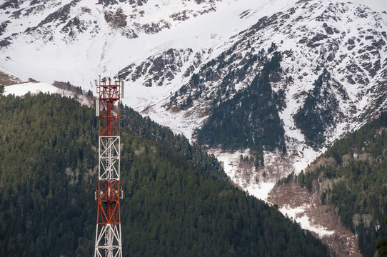 Cell tower closeup against a white sky.