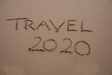 Das Wort TRAVEL 2020 in den Sand geschrieben