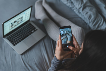 woman take picture of legs in bed for social networks