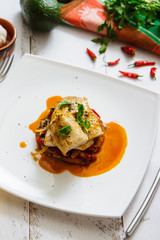 Baked fish in Basque, avocado and lemon top view. French cuisine