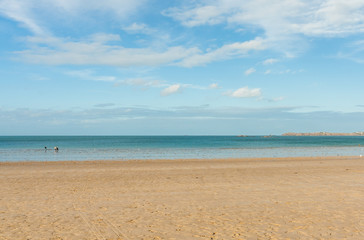 Fototapeta na wymiar Sandy beach and blue sea on bright sunny day
