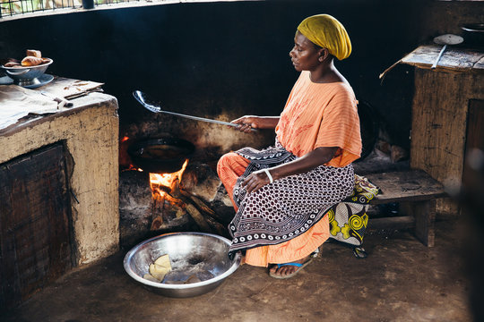 Rural african villager making bread and cooking in her kitchen