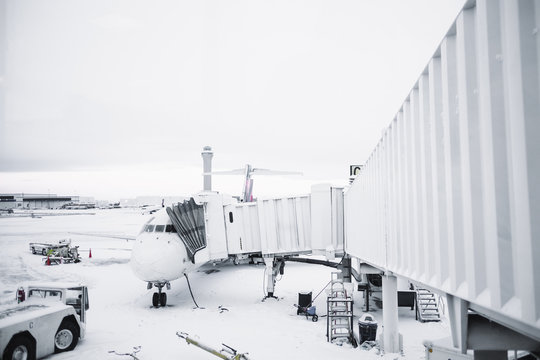 Airplane waiting at terminal with a snow covered ground
