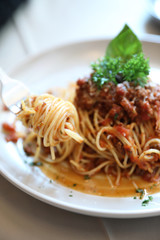 spaghetti Bolognese with minced beef and tomato sauce garnished with parmesan cheese and basil , Italian food