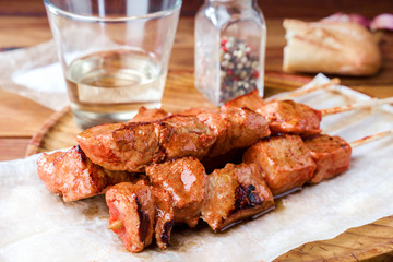 skewer of spiced pork roasted on barbecue on wood