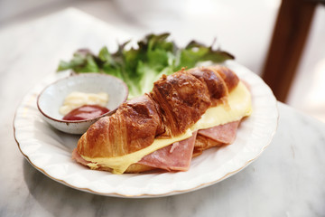 Sandwich ham and cheese on white table in coffee shop
