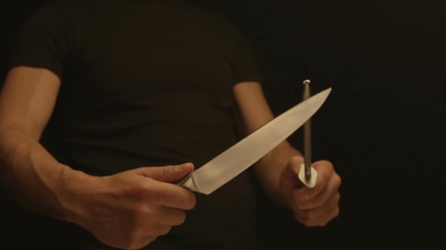 Man sharpens a knife on a sharpener