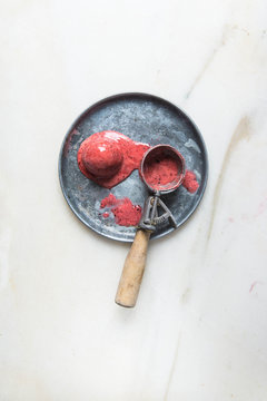 Raspberry Ice cream melting on a zinc plate