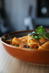 Pasta with sausage in tomato sauce on wood background , italian food