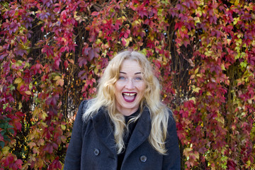 Happy smiling blond with leaves on background