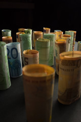 Money euro banknotes in rolls in a dark background