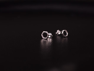 Fine silver jewelry on a black background with copy space