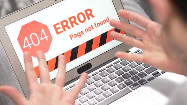 User frustrated by his laptop computer showing the error 404 message on the screen.