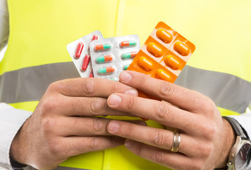 Constructor or builder hands holding pills capsules blisters.