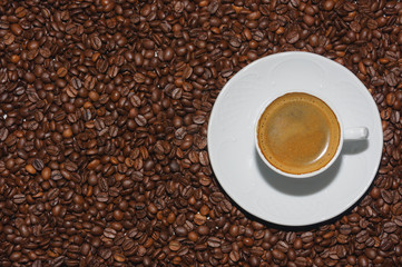 hot cup of coffee over coffee beans