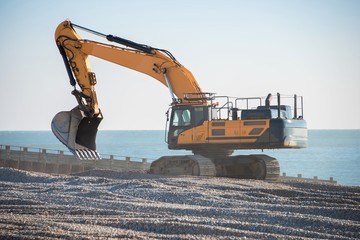 Construction Site - Engineering - Sea Defence. Large plant machinery being use to build the beach sea defence at Seaford, East Sussex, UK