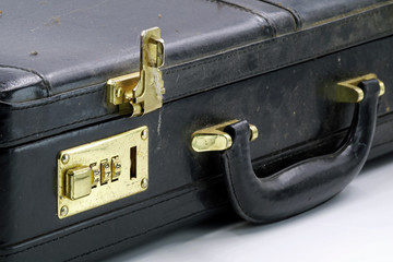 close up of an old leather briefcase with golden combination lock