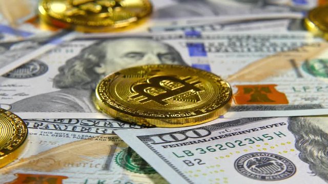 Gold coins of bitcoins and a background of hundred-dollar bills. The concept of financial operations. Economy of the future
