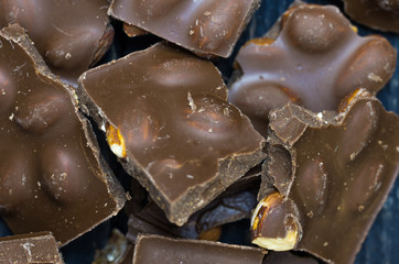 Broken pieces of chocolate. Chocolates with a nut.