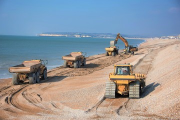 Construction - Heavy Machinery  Construction Site - Engineering  - Sea Defence.  Large plant machinery being use to build the beach sea defence at Seaford, East Sussex, UK	