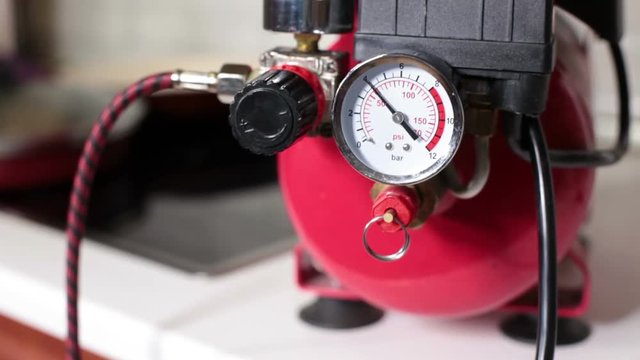 Indicator of manometer during working of air compressor and pressure increase, close up view, nobody