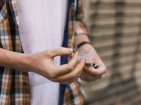 Man holding marijuana piece