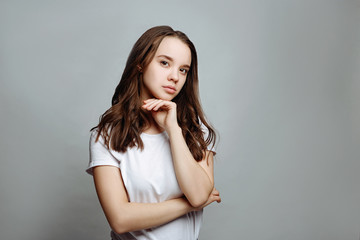 Fototapeta premium Portrait of a pretty smiling woman brunette in a white t-shirt posing isolated on a white background. 