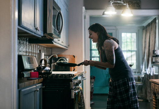 Tunes: Woman Having Fun Listening To Music While Cooking Breakfa