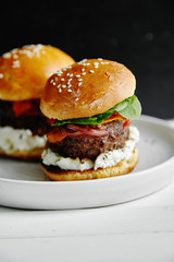 Burgers with grilled beef patties, cream cheese and spinach on classical bun.