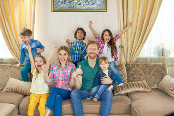 Happy family watching tv. Joyful people on the sofa. Most popular television channels.