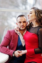 Couple in red love each other at restaurant indoor.