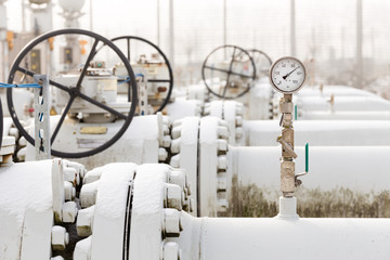 High pressure natural gas transport installation in cold winter with snow on the gas pipelines. High pressure manometer and valve to measure and secure gas transport. 