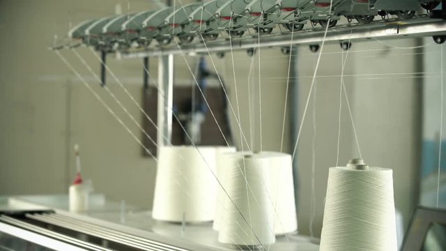 White thread spools at rewinding machine video