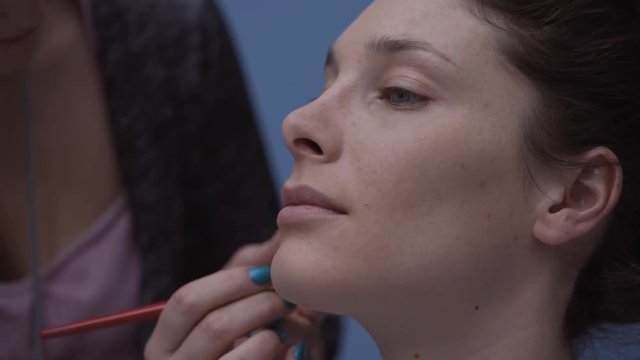Make up artist applying concealer with a brush