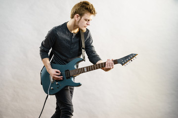Young man playing electric guitar