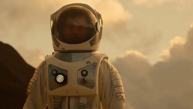 Medium Shot of the Astronaut Wearing Space Suit Walking and Exploring Mars/ Red Planet. Space Exploration, Discovery, Colonization Concept. Shot on RED EPIC-W 8K Helium Cinema Camera.