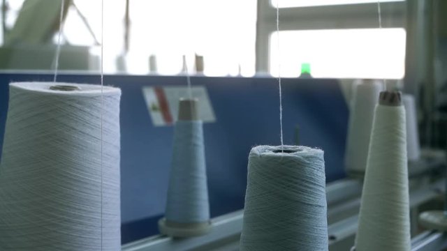 White thread spools at rewinding machine video