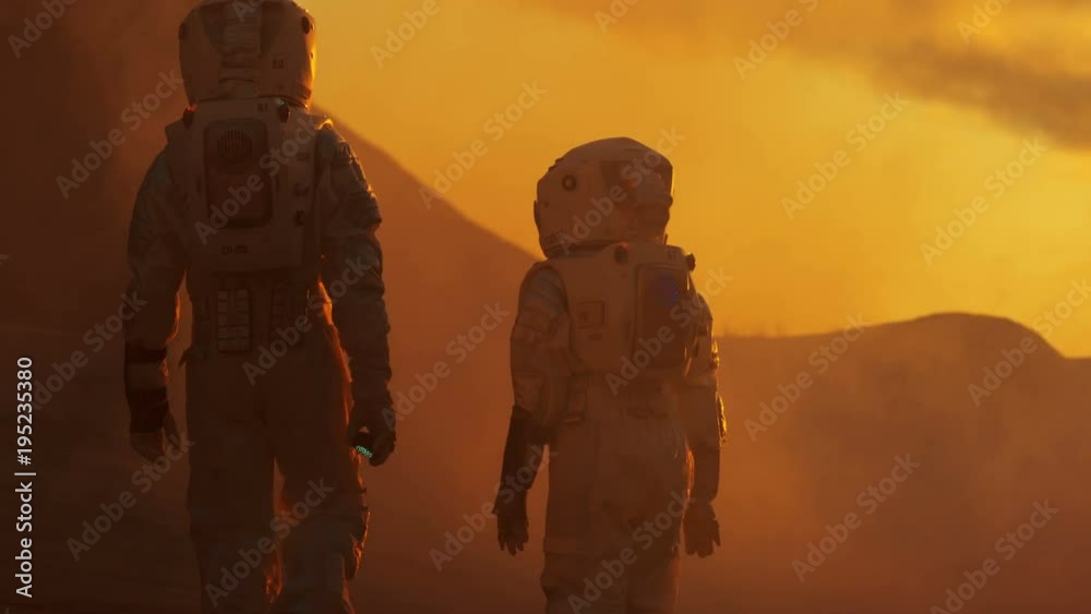 Wall mural back view of the two astronauts wearing space suits walk exploring mars/ red planet. space travel, e