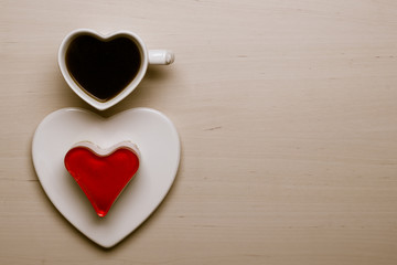 Heart shaped coffee cup and cake on wood surface